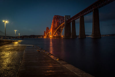 Suspension bridge over river at night
