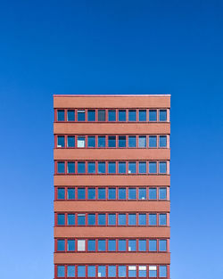 Low angle view of modern building against blue sky