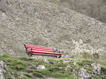 Empty bench on rock against mountain