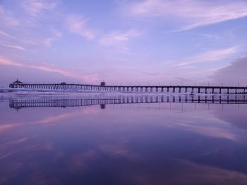 Pier over sea against sky during sunset