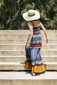 Rear view of woman standing against staircase