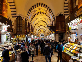 People at illuminated market stall in city