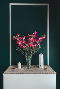 Close-up of pink flower vase on table against black background