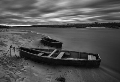 Boat moored at beach against sky