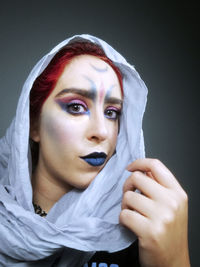 Close-up portrait of a young woman over black background