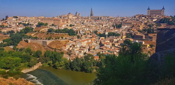 High angle view of townscape by river against sky