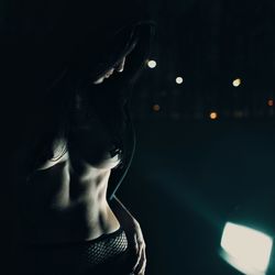 Portrait of young woman looking away at night