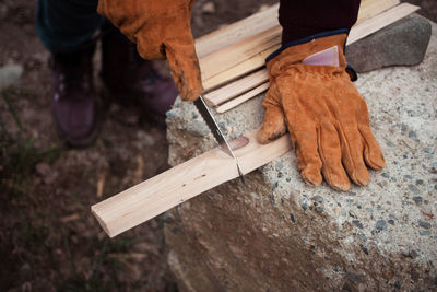 Low section of man cutting wood at workshop