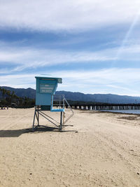 Lifeguard hut on beach against sky