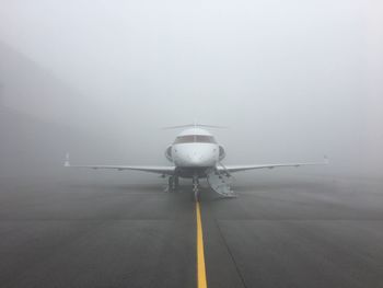 Airplane at runway during foggy weather