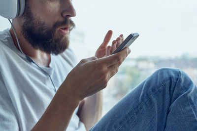 Midsection of man using mobile phone