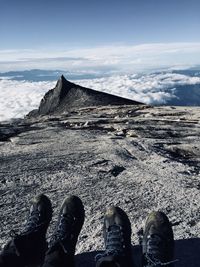 Low section of man people on mountain against sky