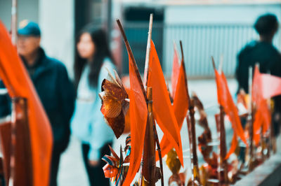 Close-up of orange decoration with people in background