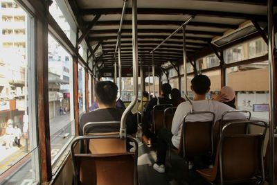 Rear view of people sitting in tram 