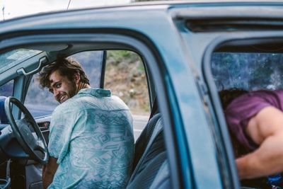 Young man sitting in car