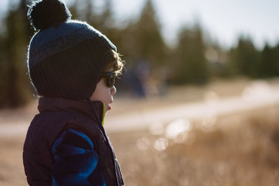 Rear view of boy standing outdoors