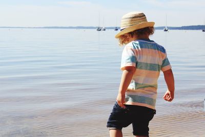 Rear view of boy standing in lake