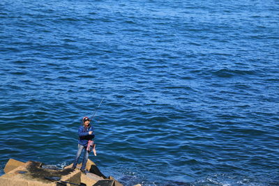 High angle view of man fishing in sea