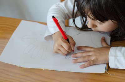 High angle view of girl drawing on paper