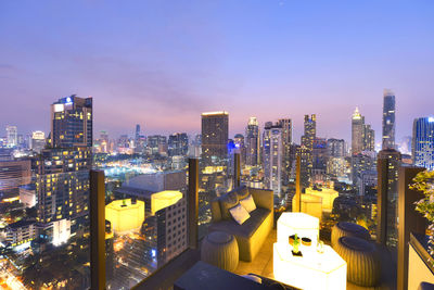 Illuminated cityscape against sky during sunset