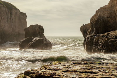 Rocks in sea against sky