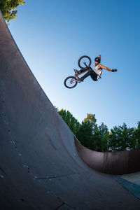 Low angle view of person riding bicycle against sky