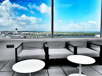 Empty chairs against cloudy sky