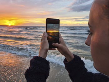 Cropped hand of woman using mobile phone