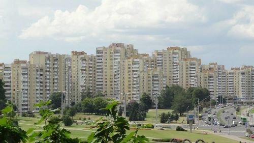 Buildings in city against cloudy sky