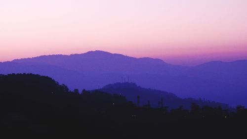 Scenic view of silhouette mountains against romantic sky at sunset