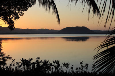 Scenic view of lake against orange sky