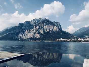 Scenic view of lake by mountains against sky