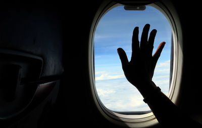 Close-up of silhouette man looking through window