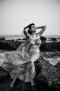 Portrait of young woman sitting on rock