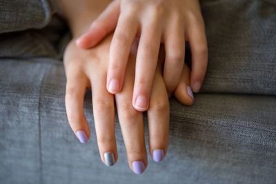 Cropped image of hands on sofa at home