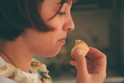 Close-up of woman eating food at home