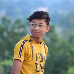 Portrait of young man wearing sunglasses standing outdoors