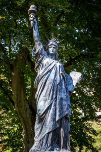 Low angle view of statue against trees