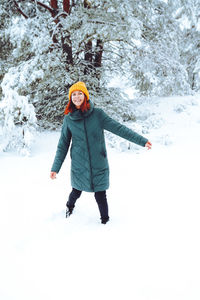 Young beautiful woman in winter forest with fir trees person