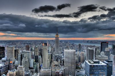 View of cityscape against cloudy sky