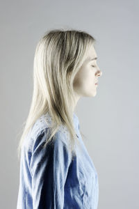 Portrait of young woman against white background