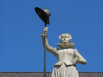 Low angle view of statue against blue sky