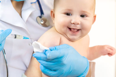 Doctor giving vaccine to baby at clinic