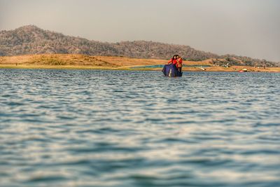 Man surfing in boat against sky