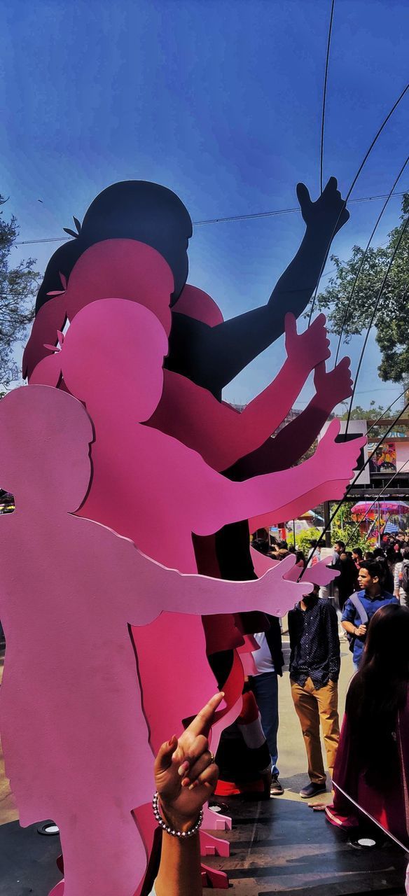 PEOPLE WITH PINK UMBRELLA AGAINST SKY DURING AUTUMN