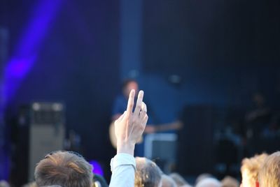 Man with hand raised in crowd during concert