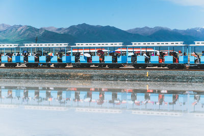 Group of people in front of lake against mountains