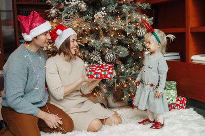 Rear view of women in christmas tree