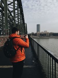 Man photographing river in city