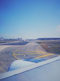 Airplane on runway against clear blue sky